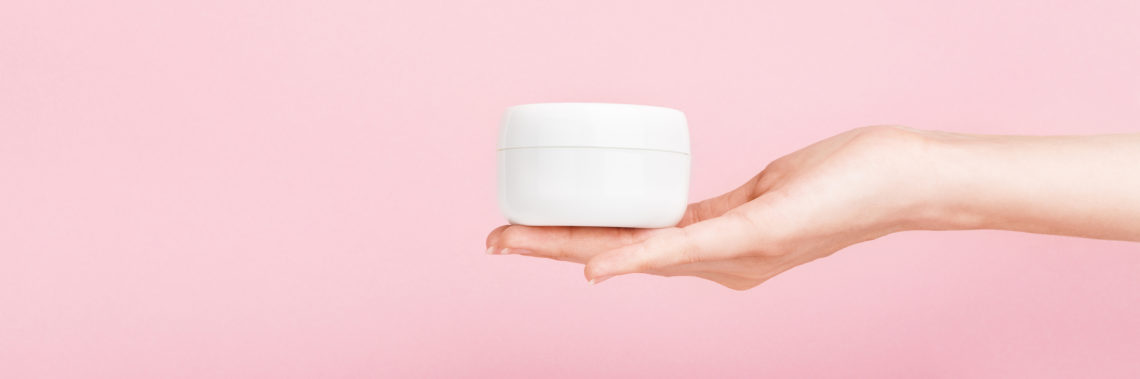 Weibliche Hand mit Cremedose